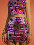 A high-waisted, bodycon mini skirt with a vibrant psychedelic floral pattern. The curve-hugging skirt features a mid-thigh length and black stitching at the waistband and hem. The all-over print consists of abstract, fuzzy-edged floral bursts in electric colors, including hot pink, magenta, neon green, and electric purple, set against a black background. The skirt is shown in two finishes: a smooth, matte signature knit and a metallic glitter knit with a reflective silver foil.