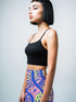 High-waisted mini skirt with a vibrant pastel tiger stripe pattern in electric blue, soft pink, yellow, and violet. The bodycon silhouette hugs curves with a comfy elastic waistband and stretch fabric. Available in smooth performance fabric or glitter finish. A maximalist fashion piece for festivals, summer outfits, and ravewear.