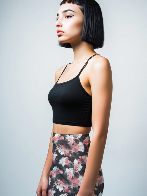 High-waisted bodycon mini skirt featuring abstract floral print in coral pink, white and charcoal grey on black background. Fitted silhouette with stretch fabric and above-knee length.