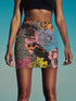 High-waisted mini skirt with a multicolor floral collage print featuring graphic roses, polka dots, and stripes. Bodycon fit in a bright palette including pink, yellow, blue, and orange. Made of stretchy poly-spandex blend and styled in colorful festival outfits. Sizes XS to XL available.