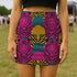 High-waisted mini skirt with bold psychedelic tiger print in hot pink, teal, yellow, and black. Features a form-fitting pencil silhouette with an elastic waistband. Available in eco-poly performance or glitter finish. Unique maximalist style for festivals, summer parties, or rave fashion. Sizes S–XL.
