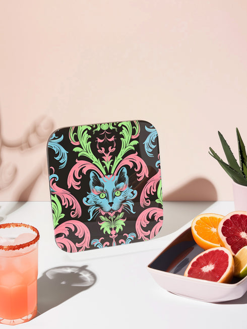 Square coasters featuring psychedelic blue cats with green eyes surrounded by baroque pink and green flourishes on black backgrounds. Gothic maximalist drink coasters for cat lovers, weird barware accessories, funky eclectic home decor, whimsigoth design.