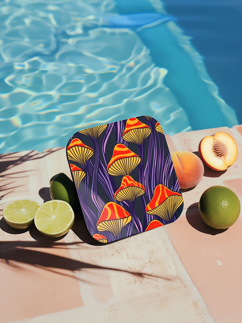 Square coasters featuring bright orange-red psychedelic mushrooms with yellow gills against deep purple background with flowing stems. Trippy magic mushroom drink coasters, funky retro barware, maximalist table decor, weird hippie home accessories.