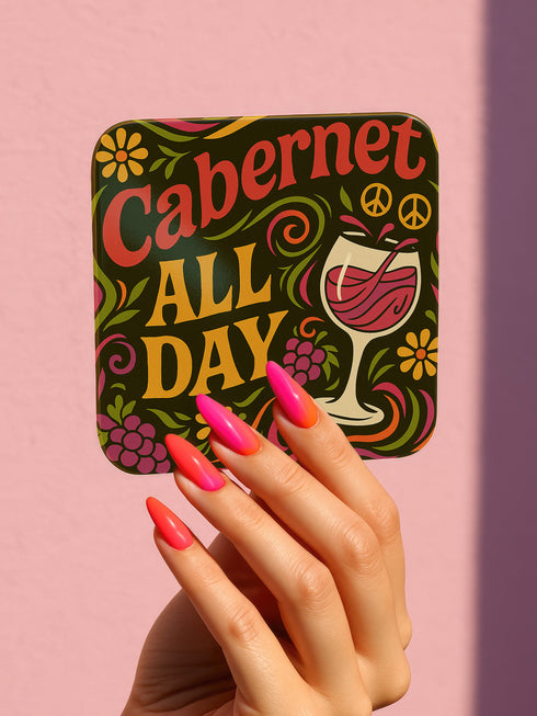 A 4-piece retro coaster set featuring colorful 70s-style cocktail graphics with playful drink quotes: "More Bubbles Less Trouble," "I Make Pour Decisions," "Cabernet All Day," and "Call Me Old-Fashioned." These 3.75” square coasters are made of Masonite with a glossy finish and cork backing—perfect for funky bar carts, dopamine décor, and retro hostess gifts.