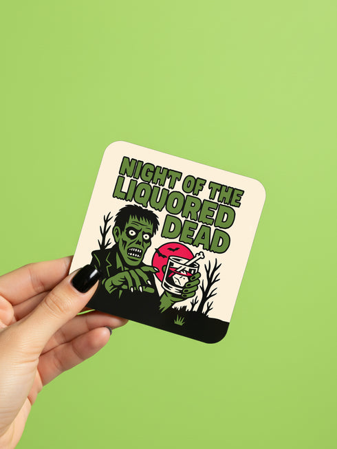 A set of four glossy square coasters on a vibrant green surface, each featuring a unique punk rock parody design. Top left: "Never Mind the Buzzkills" in yellow and pink ransom-note typography. Top right: "Night of the Liquored Dead" featuring a green zombie holding a drink in a horror comic style. Bottom left: "Too Drunk To Sip" with skeleton hands holding a wine glass on a black background. Bottom right: "God Save The Beer" featuring a green beer can on a Union Jack flag background.
