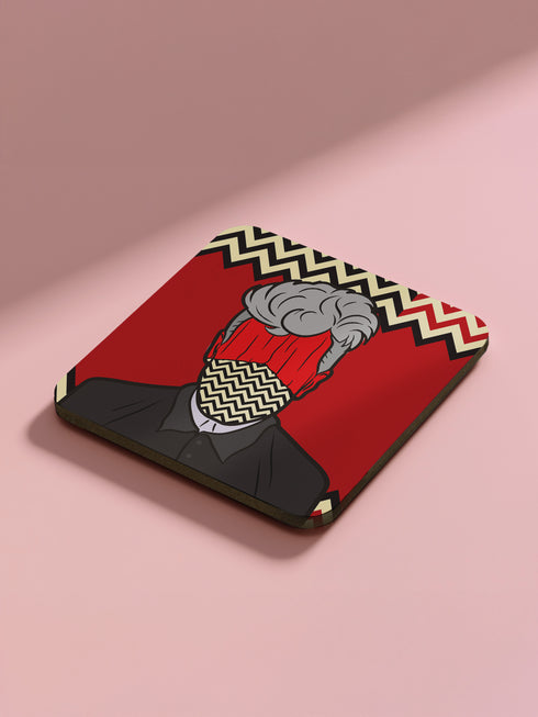 Four square coasters featuring Twin Peaks-inspired designs: Agent Cooper, the Log Lady, a coffee cup, and a mysterious blonde. Bold red backgrounds with black and white zigzag borders.