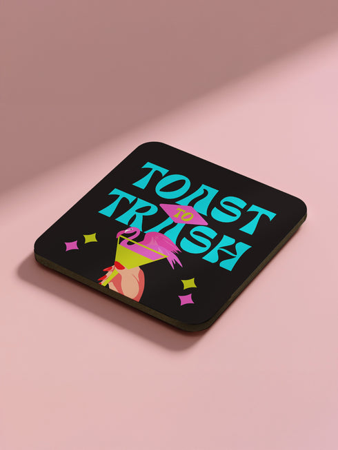 Four-piece coaster set featuring Divine/Pink Flamingos artwork with bold typography in pink, turquoise, and green. Includes "Toast to Trash," "Keeping Drinks Trashy," "Enjoy Your Filthy Drink," and Divine portrait designs.