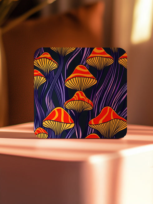 Square coasters featuring bright orange-red psychedelic mushrooms with yellow gills against deep purple background with flowing stems. Trippy magic mushroom drink coasters, funky retro barware, maximalist table decor, weird hippie home accessories.