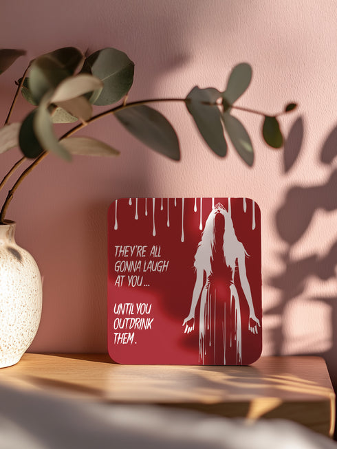 Four-piece horror movie coaster set featuring The Shining and Carrie designs in black, red, and orange with iconic quotes and imagery from the films. Cork-backed hardboard construction.