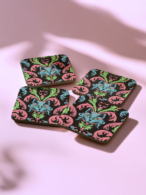 Square coasters featuring psychedelic blue cats with green eyes surrounded by baroque pink and green flourishes on black backgrounds. Gothic maximalist drink coasters for cat lovers, weird barware accessories, funky eclectic home decor, whimsigoth design.