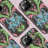 Phone case featuring baroque-style blue cat with green eyes surrounded by mint green foliage and pink flourishes on black background, Victorian-inspired desig
