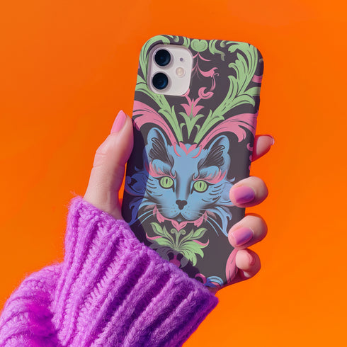 Phone case featuring baroque-style blue cat with green eyes surrounded by mint green foliage and pink flourishes on black background, Victorian-inspired desig