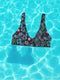 Black Cherry floral bikini top with deep V neckline, bold pink and purple tropical flowers, glossy leaves, and subtle fruit pattern. Made with recycled polyester and LYCRA, removable padding, double-layered, available in sizes XS to 3XL, features UPF 50 plus sun protection, non-reversible. Designed for festival, rave, and retro summer swim looks.