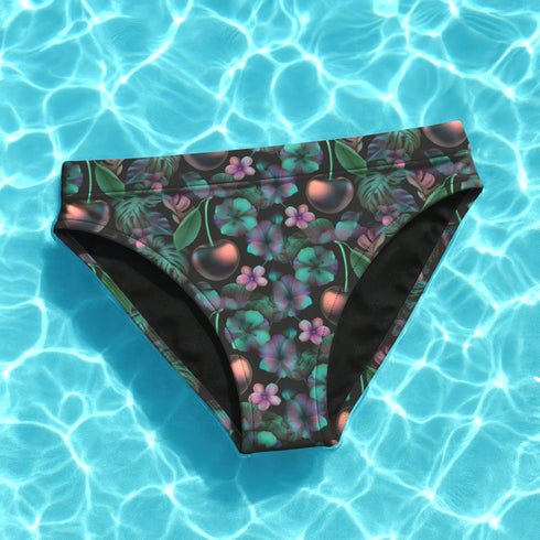 Dark Cherry floral bikini bottoms featuring a bold cherry and tropical flower pattern with deep green and purple leaves, made from moisture-wicking polyester and spandex, cheeky fit, mid-rise, available in sizes XS to 3XL, double-lined with UPF 50 plus sun protection. Perfect for rave outfits, summer festivals, beach goth, and retro pool parties.