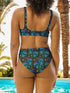 Two-piece high-waisted bikini set featuring an all-over print of blue skulls with purple bows and multicolored stars on a dark background. Includes a deep V-neck bikini top with wide straps and matching high-rise bottoms. Made from soft, stretchy fabric with a smooth black inner lining. The design combines bold, edgy graphics with a flattering retro-inspired silhouette.