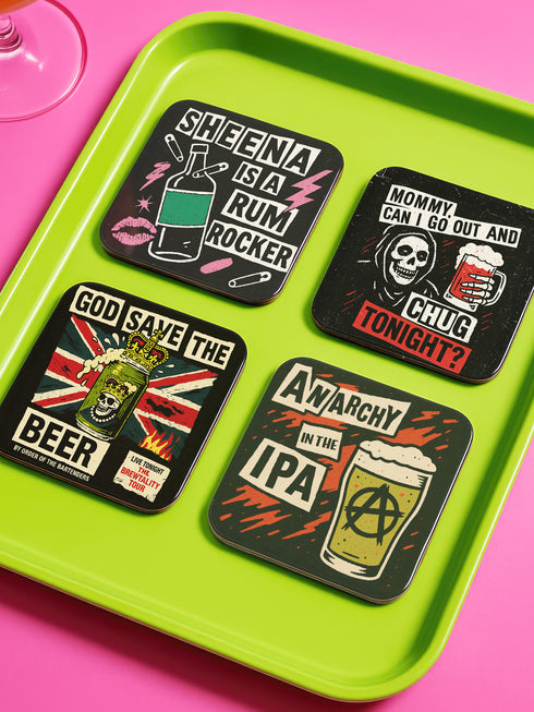 A 4-piece square coaster set featuring punk rock-inspired designs in a bold, vintage art style. Includes slogans like “Sheena Is A Rum Rocker,” “God Save the Beer,” and “Anarchy in the IPA.” Made of Masonite with cork backing, these 3.75 x 3.75-inch coasters are perfect for music lovers, goth homes, and alternative wedding or housewarming gifts.