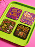 A 4-piece retro coaster set featuring colorful 70s-style cocktail graphics with playful drink quotes: "More Bubbles Less Trouble," "I Make Pour Decisions," "Cabernet All Day," and "Call Me Old-Fashioned." These 3.75” square coasters are made of Masonite with a glossy finish and cork backing—perfect for funky bar carts, dopamine décor, and retro hostess gifts.