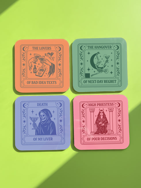 "A set of four square coasters featuring humorous tarot card designs in pastel colors. The set includes a pink coaster titled 'High Priestess of Pour Decisions' showing a witch holding a goblet, a purple coaster titled 'Death of My Liver' depicting a skeleton holding a martini, an orange coaster titled 'The Lovers of Bad Idea Texts' featuring two hands toasting, and a green coaster titled 'The Hangover of Next-Day Regret' showing a skeleton falling. Glossy finish.