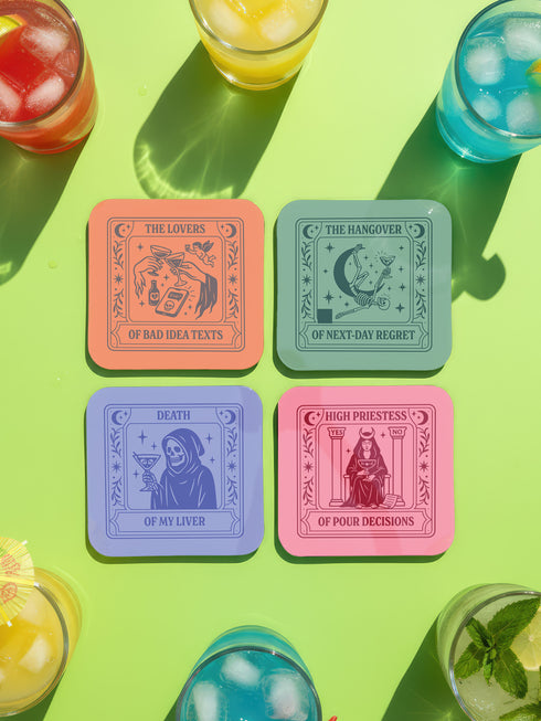 A set of four square coasters featuring humorous tarot card designs in pastel colors. The set includes a pink coaster titled 'High Priestess of Pour Decisions' showing a witch holding a goblet, a purple coaster titled 'Death of My Liver' depicting a skeleton holding a martini, an orange coaster titled 'The Lovers of Bad Idea Texts' featuring two hands toasting, and a green coaster titled 'The Hangover of Next-Day Regret' showing a skeleton falling. Glossy finish.
