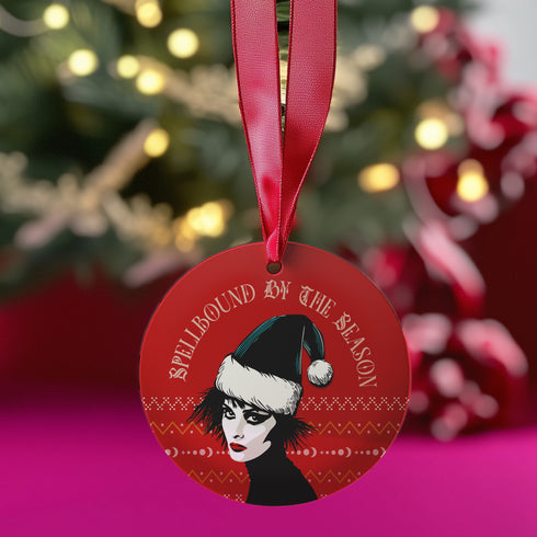 Round red metal Christmas ornament featuring Siouxsie Sioux in black and white with Santa hat, geometric patterns, and 'Spellbound by the Season' text, suspended by red ribbon