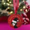 Round red metal Christmas ornament featuring Siouxsie Sioux in black and white with Santa hat, geometric patterns, and 'Spellbound by the Season' text, suspended by red ribbon