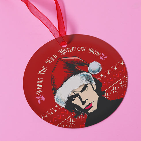 "Round red metal Christmas ornament featuring Nick Cave in black and white with Santa hat, Nordic patterns, and 'Where The Wild Mistletoes Grow' text, suspended by red ribbon