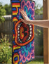 A rectangular indoor and outdoor doormat featuring a vibrant, psychedelic design. The central graphic is a large, open screaming red and orange mouth with white teeth, surrounded by highly saturated wavy, trippy patterns in blue, purple, magenta, and teal. Yellow stylized text reading HELLO is integrated into the pattern. The mat has a smooth 2D flat print surface that mimics the look of textured chainstitch embroidery, finished with a solid black fabric trim around all four outer edges.