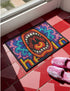 A rectangular indoor and outdoor doormat featuring a vibrant, psychedelic design. The central graphic is a large, open screaming red and orange mouth with white teeth, surrounded by highly saturated wavy, trippy patterns in blue, purple, magenta, and teal. Yellow stylized text reading HELLO is integrated into the pattern. The mat has a smooth 2D flat print surface that mimics the look of textured chainstitch embroidery, finished with a solid black fabric trim around all four outer edges.