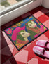 A rectangular non-slip doormat with a black trimmed edge. The mat features a vibrant, colorful folk art illustration on a dark navy blue background with a faux embroidered texture. The design depicts two friendly opossums, rendered in an olive green color with white faces and pink noses. They are surrounded by large, stylized flowers and leaves in shades of hot pink, red, turquoise, and yellow, creating a busy, maximalist pattern. The overall aesthetic is eclectic, whimsical, & highly detailed.
