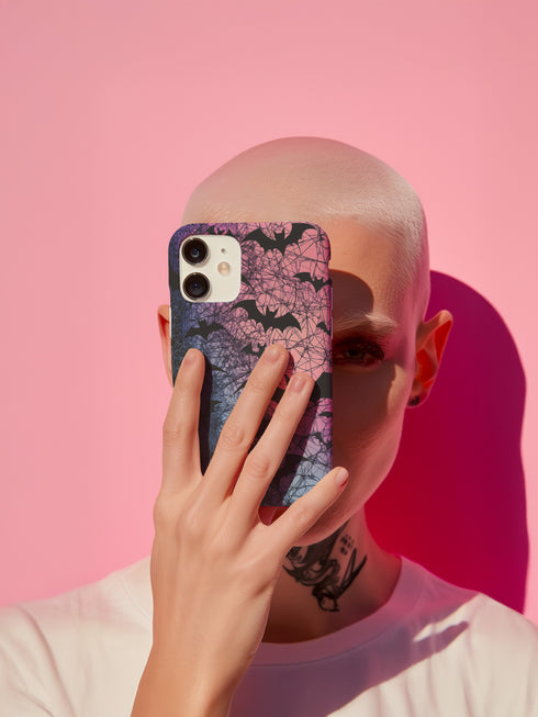 A pastel gothic phone case featuring black bat silhouettes over a gradient pink-to-blue ombré background with web-like detailing. Available for iPhone, Samsung, and Google Pixel models in matte or glossy finishes with dual-layer protection.