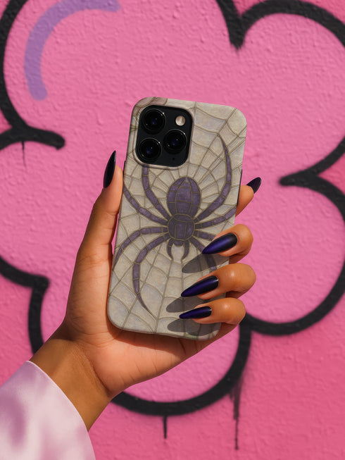 Gothic phone case featuring purple spider web design with detailed black spider on stained glass background with rose accents. Spooky Halloween phone cover with intricate web pattern and gothic aesthetic perfect for iPhone Samsung Galaxy Pixel models. Dark romantic phone protection with vintage stained glass mosaic style spider web art and floral elements.