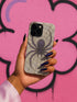 Gothic phone case featuring purple spider web design with detailed black spider on stained glass background with rose accents. Spooky Halloween phone cover with intricate web pattern and gothic aesthetic perfect for iPhone Samsung Galaxy Pixel models. Dark romantic phone protection with vintage stained glass mosaic style spider web art and floral elements.