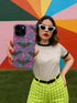 A protective phone case featuring a stained glass-style design in shades of purple, blue, and pink, with black bats flying across geometric panels outlined in gold. The case has a smooth matte finish and fits a triple-camera smartphone model.