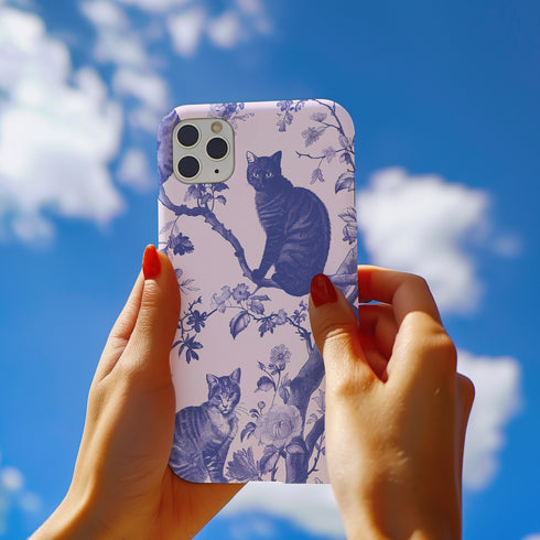 Phone case featuring a blue and pink toile pattern with cats, flowers, and botanical designs. Dual-layer protection available in glossy or matte finish.