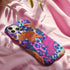 Vibrant phone case with orange tigers on colorful abstract background. Maximalist design featuring multiple tigers and bold purple, pink, and blue patterns. Copy