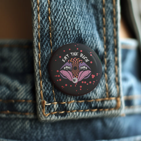 Black circular pin badge with purple fanged mouths design, psychedelic orange spiral, and "EAT THE RICH" text in white, scattered with red dotsBlack circular pin badge with purple fanged mouths design, psychedelic orange spiral, and "EAT THE RICH" text in white, scattered with red dots