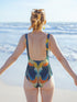 Bored with basic? This swimsuit slaps reality in the face and dares it to get weird. Our psychedelic one-piece serves major 70s acid trip energy with swirling teal, sunshine yellow, and fiery orange wavelengths that'll make your beach presence impossible to ignore. Festival freak, pool party provocateur, or beach goth queen — whoever you are, this vintage-inspired witchy swimsuit transforms your water adventures into a technicolor rebellion against boring beachwear. Designed for the maximalist who knows tha
