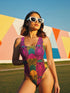 High-cut one-piece swimsuit with a bold psychedelic tiger print in hot pink, yellow, green, teal, and black. Features tiger faces, zebra stripes, and fan-shaped motifs in a maximalist retro style. Made from 81% recycled polyester and 19% LYCRA XTRALIFE. Includes cheeky fit and UPF50+ sun protection. Double layered and non-reversible. Available in sizes XS to 3XL.