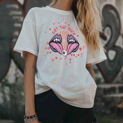 White t-shirt featuring a surreal, psychedelic design centered on the chest. An open mouth with sharp vampire-like teeth and pink tongue dominates the image. Between the teeth, a hypnotic swirling pattern in rainbow colors leads to a single eyeball on the tongue. "EAT THE RICH" is written in white above the mouth. Red paint-like splatters surround the entire design, giving it a grungy, punk aesthetic. The shirt is from the "Honey Dazed" brand.