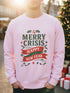 A holiday sweatshirt in pink or red with a punk and goth aesthetic. The text reads "MERRY CRISIS" and "HAPPY NEW FEAR" in a bold, gothic-style font. The design is decorated with holly leaves, berries, thorny vines, and safety pins, all arranged in a festive but alternative holiday style. This funny goth Christmas pullover is a sarcastic statement piece, perfect as dark humor apparel for the winter season.