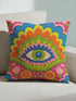 Polyester faux embroidered pillow cover featuring a bold maximalist evil eye design with a colorful folk-art inspired pattern. The front print includes a central blue, green, and pink eye surrounded by scalloped floral shapes, rainbow-like arches, leafy details, and bright decorative flowers in pink, orange, yellow, blue, and green. Soft square pillow cover with a textured woven-look print. Available in 18x18 or 22x22 inches.