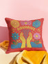 A square red decorative pillow featuring a flat, faux-embroidery design of the Aquarius zodiac sign. The word "AQUARIUS" curves in yellow letters above two yellow hands catching falling blue raindrops. Stylized pink and blue folk-art flowers and green leaves flank the hands, with blue waves at the bottom. The design mimics the texture of stitched thread but is a smooth 2D print.