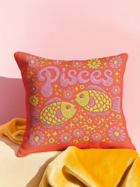 A vibrant tomato red square throw pillow featuring a retro 70s Pisces zodiac design in a faux embroidery print style. The word Pisces appears in bubblegum pink bubble letters at the top, sitting above two yellow and pink fish swimming in a circle representing the water sign. The background is densely filled with yellow and pink daisies. The texture visually mimics stitched needlework but is a smooth 2D print on linen-feel fabric. Perfect for maximalist, eclectic, and dopamine decor styles.
