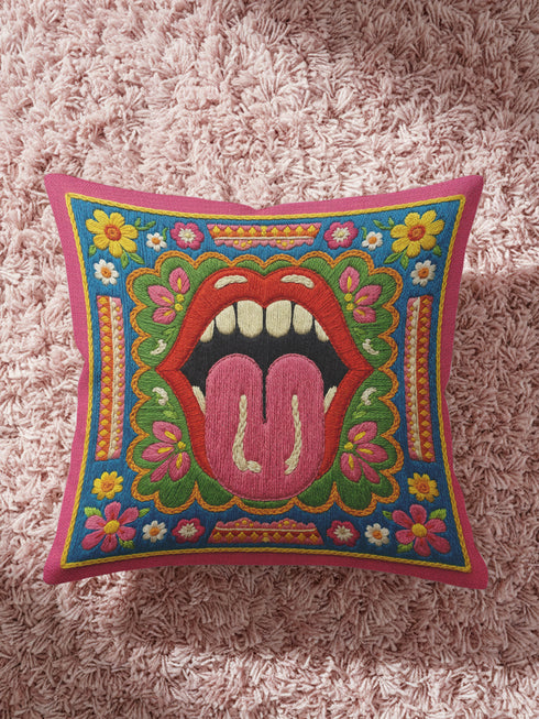 Maximalist throw pillow cover featuring a printed faux embroidery design with red open lips, pink tongue, white teeth, green scalloped medallion border, yellow and pink flowers, and decorative folk-inspired bands on a bright blue background with hot pink edging. Square colorful pillowcase for eclectic home decor, retro interiors, dopamine decor, boho living rooms, statement sofas, beds, chairs, and reading nooks.
