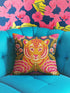 Square decorative throw pillow cover featuring a vibrant, maximalist illustration of a walking tiger surrounded by blooming pink peonies and green foliage. The design is set against a deep teal-charcoal background and mimics the texture of vintage hand embroidery with a faux-stitch printed effect. The style blends Junglecore, Chinoiserie, and Whimsigoth aesthetics. The fabric is a durable, linen-textured spun polyester. The tiger is orange, gold, and black; flowers are magenta pink.