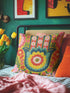 A square decorative throw pillow featuring a vibrant Hamsa hand and Evil Eye design on a hot pink background. The maximalist print includes bold blue, red, and green protection symbols with intricate details, offering a retro 70s and eclectic aesthetic. The fabric has a high-end linen texture with a hidden zipper. Available in 18x18 and 22x22 sizes.