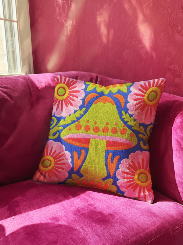 A square throw pillow cover featuring a detailed maximalist baroque mushroom design on a dark background. The pattern displays vibrant orange, red, and purple toadstools intertwined with green ferns and vintage botanical foliage. The style combines dark cottagecore with psychedelic art. The fabric possesses a premium linen texture visible in the close-up. The print appears on both sides. A hidden zipper sits at the bottom seam. The pillow is shown as a case only without an insert inside.