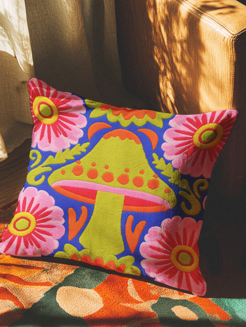 A square throw pillow cover featuring a detailed maximalist baroque mushroom design on a dark background. The pattern displays vibrant orange, red, and purple toadstools intertwined with green ferns and vintage botanical foliage. The style combines dark cottagecore with psychedelic art. The fabric possesses a premium linen texture visible in the close-up. The print appears on both sides. A hidden zipper sits at the bottom seam. The pillow is shown as a case only without an insert inside.