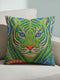 A square decorative throw pillow cover featuring a detailed illustration of a green tiger face in an Art Nouveau style. The tiger has piercing blue eyes and a bright orange nose, surrounded by intricate swirling botanical leaves in shades of teal and sage. The design mimics the look of embroidery or needlepoint but is a flat print on textured faux linen fabric. The background is a deep blue-green. The image is symmetrical and bold, fitting maximalist or junglecore aesthetics
