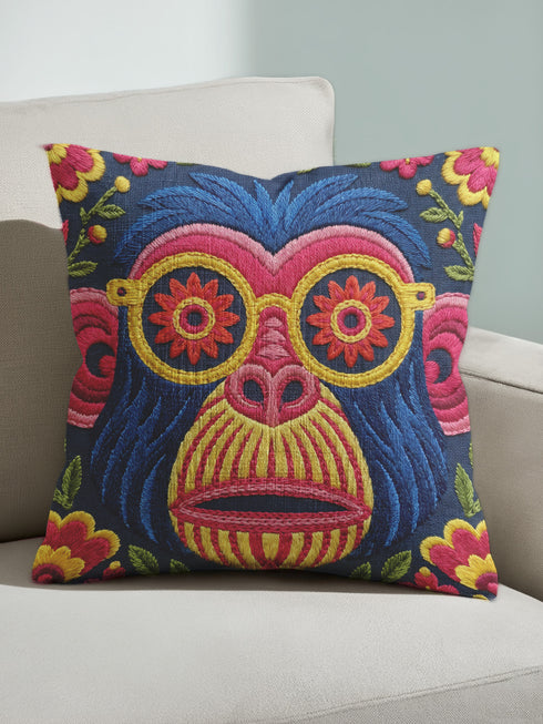 quare throw pillow cover with a faux embroidery 2D print of a stylized monkey face in large round yellow sunglasses with red flower lenses. The ape has electric blue fur with a hot pink brow and nose, on a navy background scattered with hot pink, yellow, and red flowers and green leaves. The print mimics raised stitching while staying flat and smooth, and shows on both sides. Cover only, available in 18 by 18 inch and 22 by 22 inch sizes.